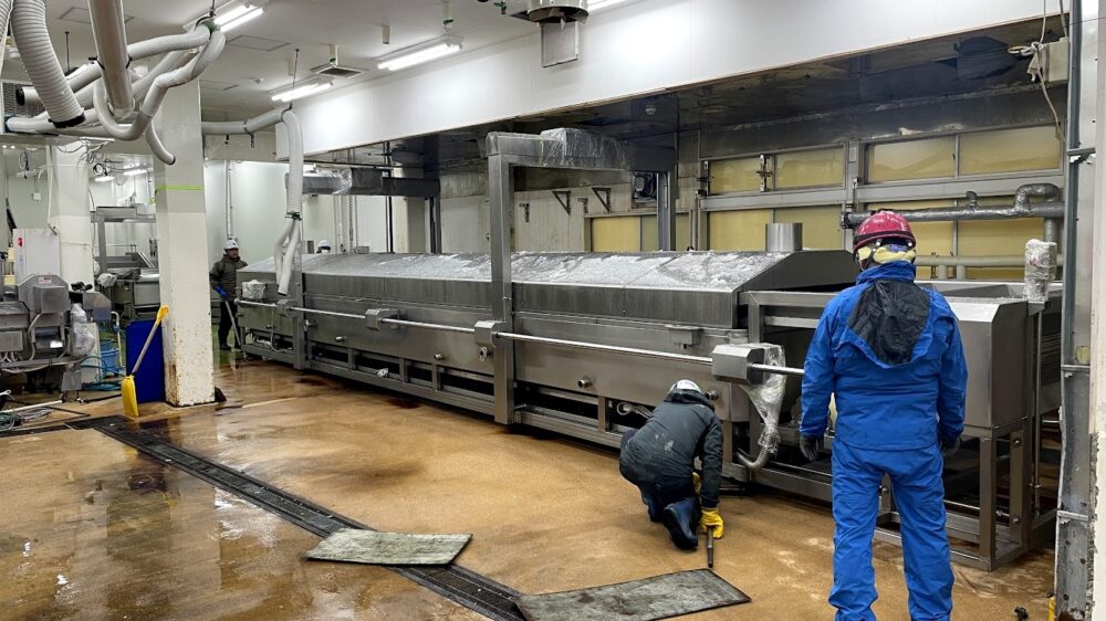 食品工場内での連続ベルト式ボイル・クール装置の設置作業風景